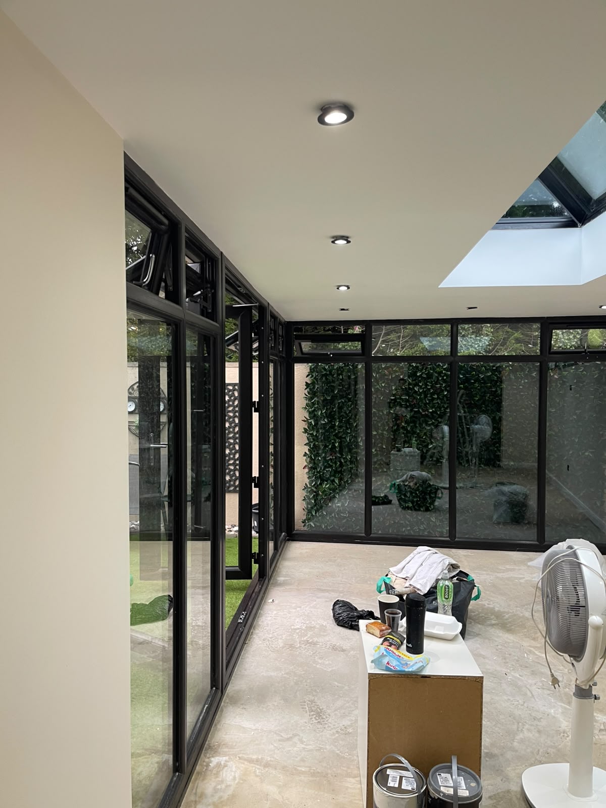Freshly painted sunroom walls alongside full-height garden windows
