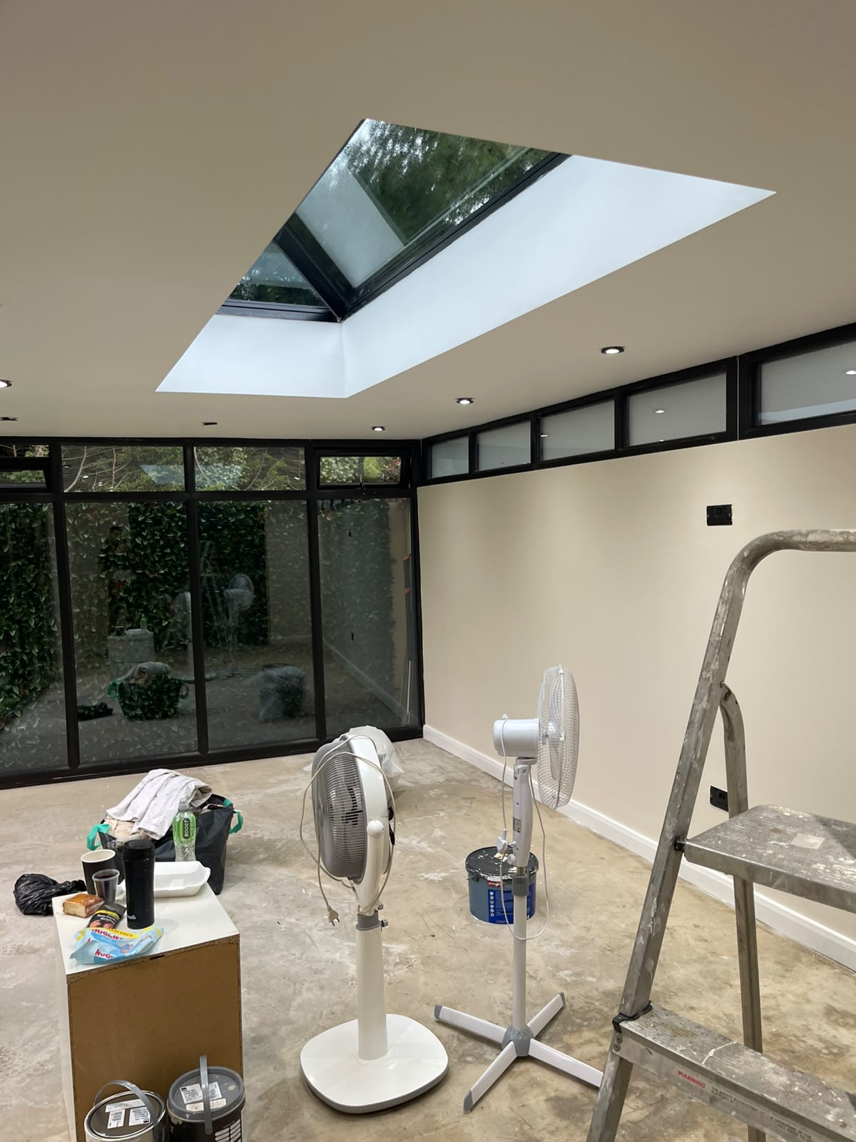 Sunroom after painting with pale walls and a freshly painted ceiling around the roof lantern