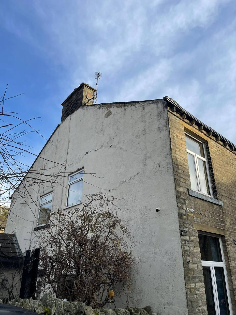 Weathered, stained gable-end render before painting